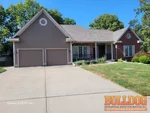 Exterior of 30-year-old reverse 1.5-story home in Willow Brooke subdivision of Kansas City, MO — 64155 (39.2629N, 94.5644W)