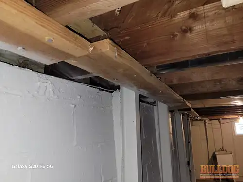 Single 2x6 wood bracket anchoring I-beam - Marlborough Heights, Kansas City, MO - December 2025 - inadequate support