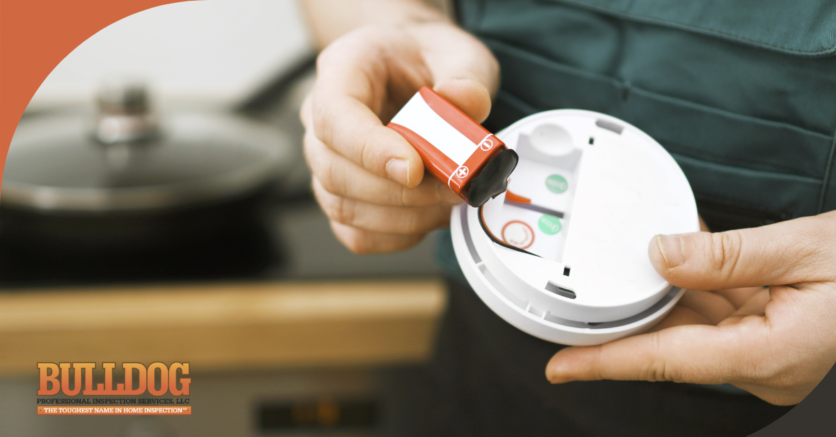 Person replacing the battery in a smoke detector.