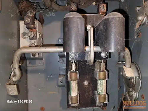 fuse-panel-st-joseph-mo-2908-charles-st-64501-39.76490330N-94.82162770W-bulldog-home-inspections-20251217_131122 Vintage fuse panel with plug fuses - Brookdale Addition, St. Joseph, MO - December 2025 - 105-year-old bungalow