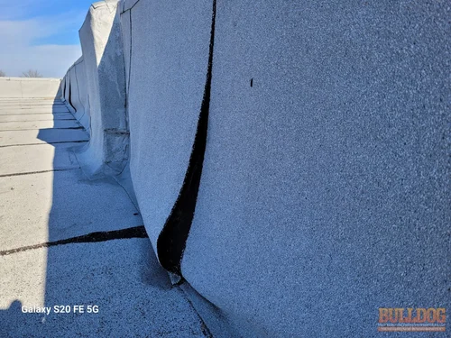 open-seam-at-flat-roof-adrian-mo-145-e-main-st-64720-38.39721100N-94.35103750W-bulldog-home-inspections-20251205_111933 Open seam at flat roof parapet wall - Adrian, MO - December 2025 - membrane separation on commercial building