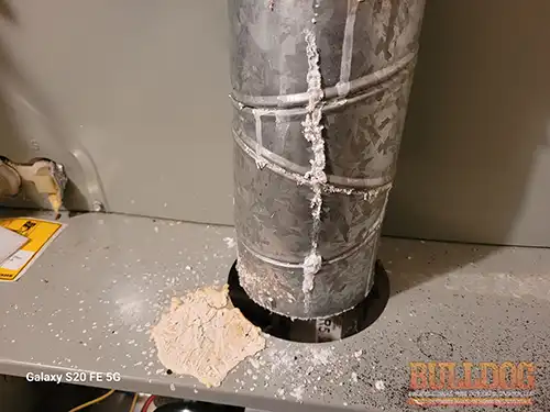 zinc-oxide-furnace-vent-kansas-city-ks-6851-garfield-dr-66102-39.12537190N-94.73748000W-bulldog-home-inspections-20251204_150310 Corroded furnace vent pipe with zinc oxide buildup - Kansas City, KS - December 2025 - 58-year-old ranch